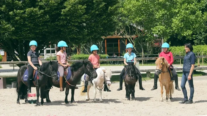 Jeunes cavaliers à poneys en carrière 