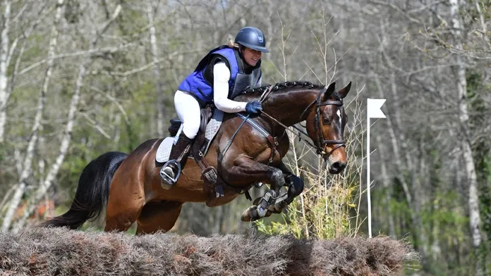 Cavalière et son cheval sautant un obstacle de cross
